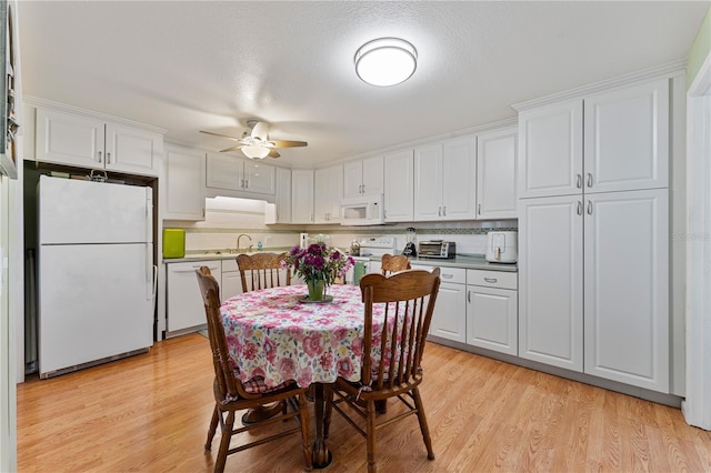 interior space with a textured ceiling, a toaster, light wood-style flooring, and a ceiling fan