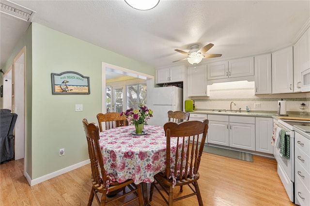 kitchen featuring visible vents, light countertops, white appliances, and white cabinetry