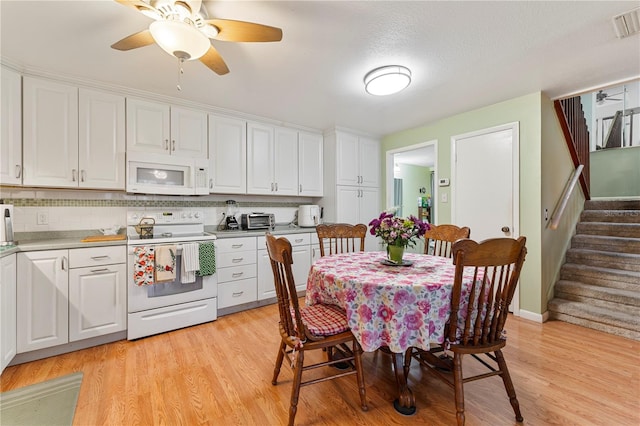 kitchen featuring tasteful backsplash, white appliances, light wood-style floors, and white cabinets