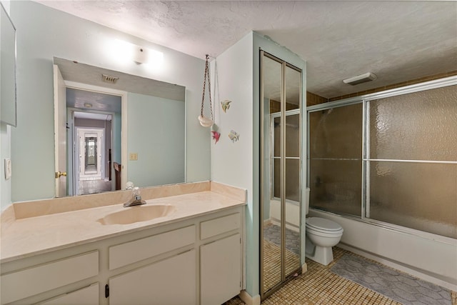 bathroom with toilet, shower / bath combination with glass door, tile patterned flooring, a textured ceiling, and vanity