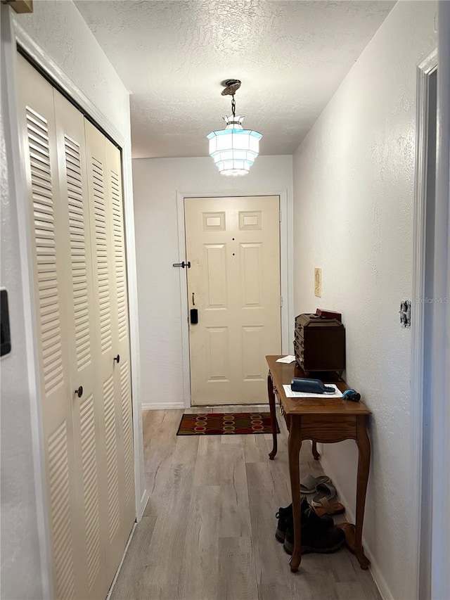 entryway with light hardwood / wood-style flooring and a textured ceiling