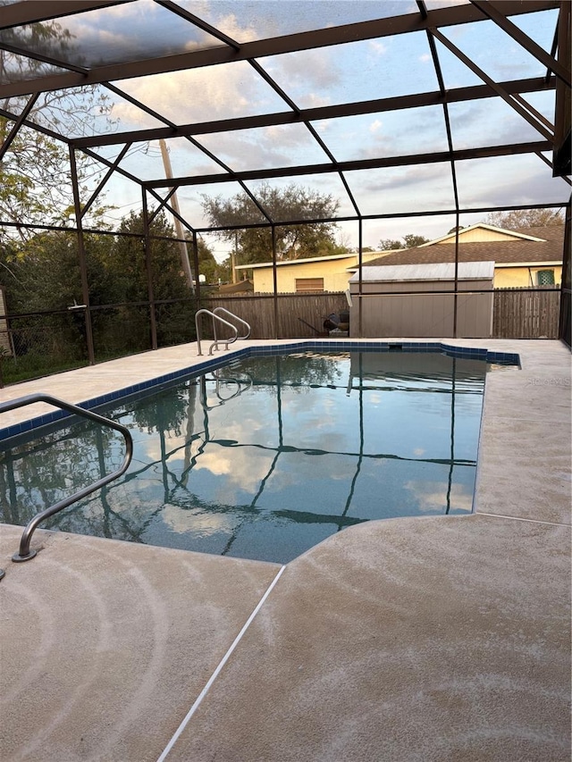 view of swimming pool featuring glass enclosure and a patio area