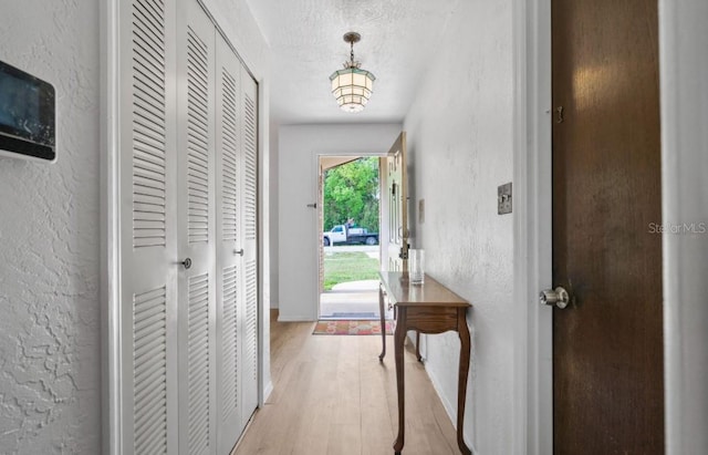 1420 Felton St, Deltona, FL 32725 - doorway to outside with a textured wall, light wood finished floors, a textured ceiling, and baseboards