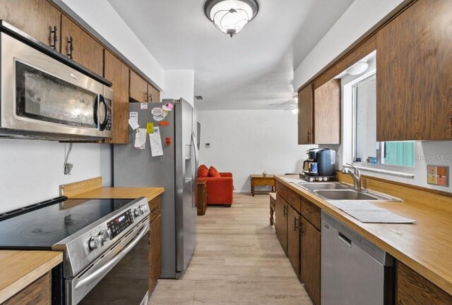 1420 Felton St, Deltona, FL 32725 - kitchen featuring stainless steel appliances, a sink, and light wood-style flooring