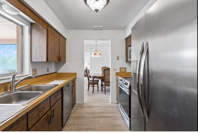 1420 Felton St, Deltona, FL 32725 - kitchen featuring stainless steel appliances, a sink, light wood-style flooring, baseboards, and light countertops