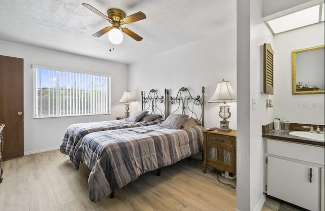1420 Felton St, Deltona, FL 32725 - bedroom with light wood finished floors, a sink, baseboards, and a ceiling fan
