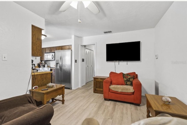 1420 Felton St, Deltona, FL 32725 - living room with light wood finished floors and a ceiling fan