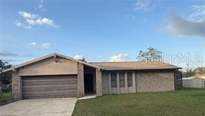 1420 Felton St, Deltona, FL 32725 - view of front of house with a garage, concrete driveway, and a front lawn