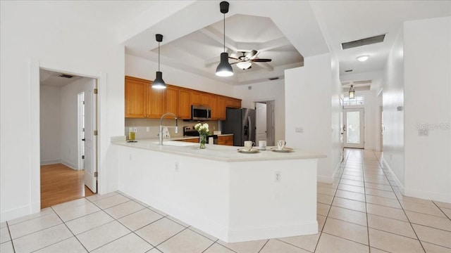 kitchen with appliances with stainless steel finishes, ceiling fan, light tile patterned flooring, and kitchen peninsula