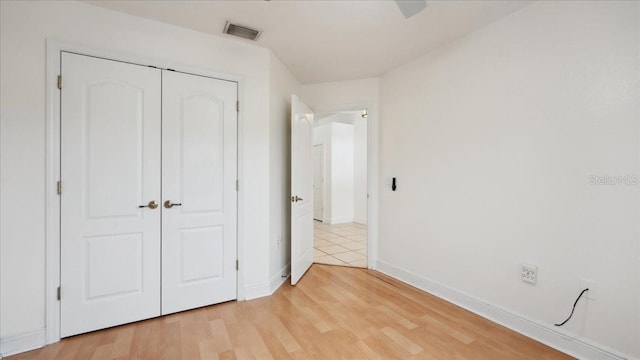 unfurnished bedroom with light hardwood / wood-style floors and a closet