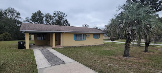 view of front of house with driveway, a front yard, and stucco siding