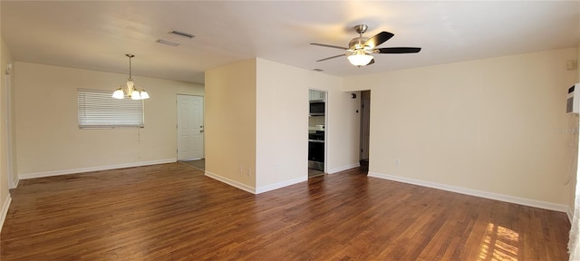 spare room with dark wood-style floors, visible vents, baseboards, and ceiling fan with notable chandelier