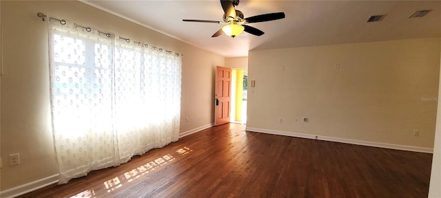 unfurnished room featuring dark wood-type flooring, a ceiling fan, visible vents, and baseboards