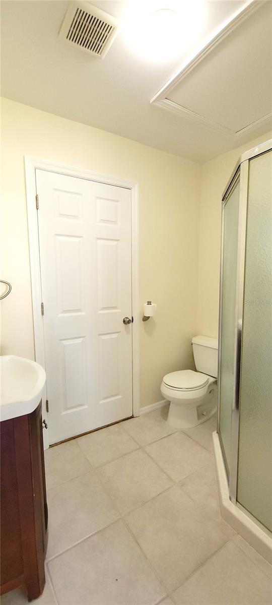 full bathroom with a stall shower, tile patterned flooring, vanity, and visible vents