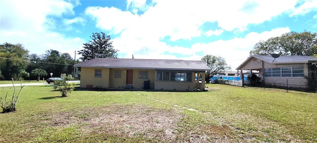 rear view of house featuring a yard and stucco siding