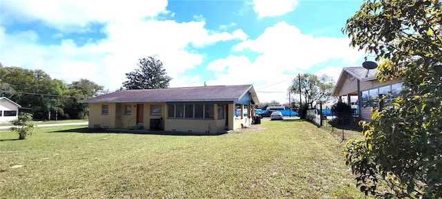 view of front facade with stucco siding, fence, and a front yard