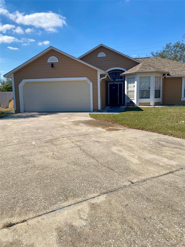 single story home featuring a garage, driveway, and a front yard