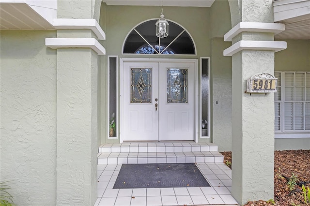 entrance to property featuring french doors and stucco siding