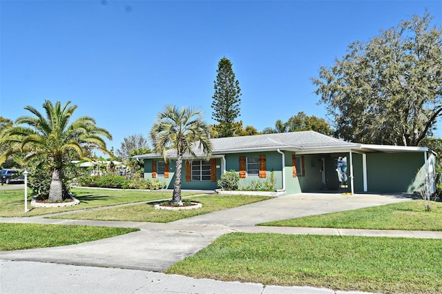 view of front of house with driveway, a front lawn, an attached carport, and stucco siding