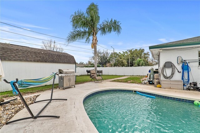 445 Virginia Ave, Saint Cloud, FL 34769 - view of swimming pool with area for grilling, a fenced backyard, a patio, and a storage unit