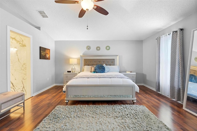 bedroom featuring baseboards, visible vents, dark wood finished floors, and a textured ceiling