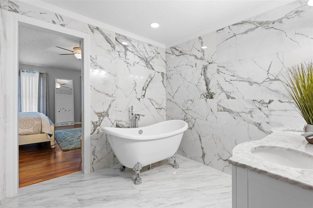 ensuite bathroom with stone wall, ensuite bath, and a freestanding bath