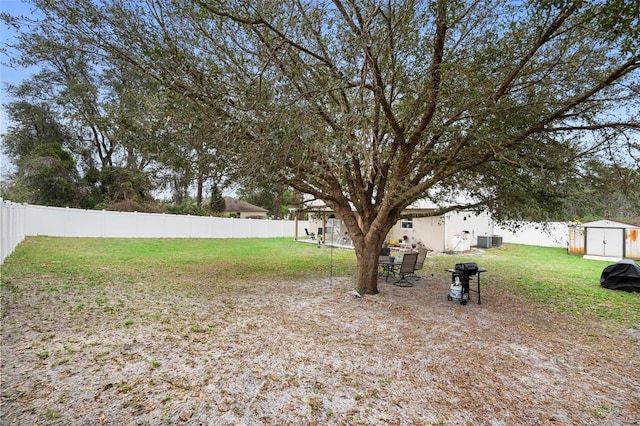 view of yard featuring a fenced backyard, an outdoor structure, and a shed