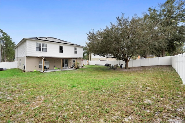 back of house featuring a fenced backyard, a lawn, and a patio