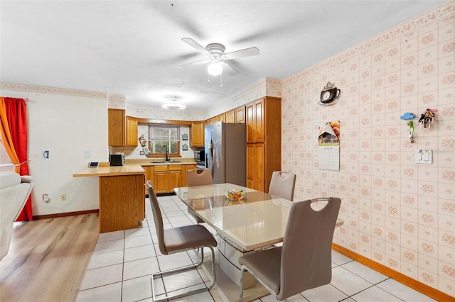 dining space featuring wallpapered walls, light tile patterned floors, baseboards, and a ceiling fan