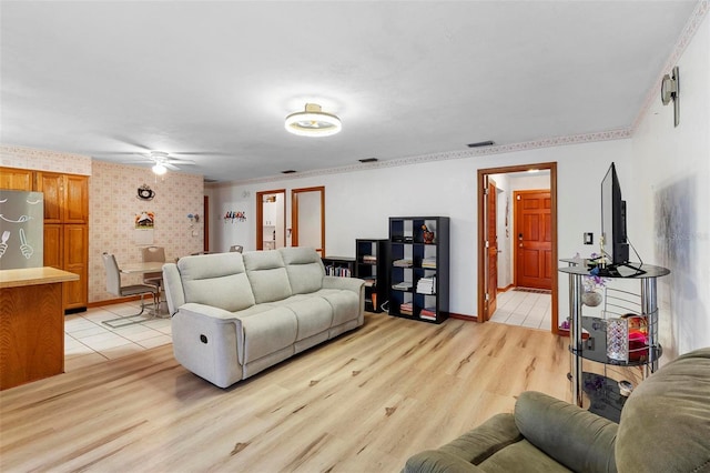 living area with visible vents, a ceiling fan, light wood-style flooring, and baseboards