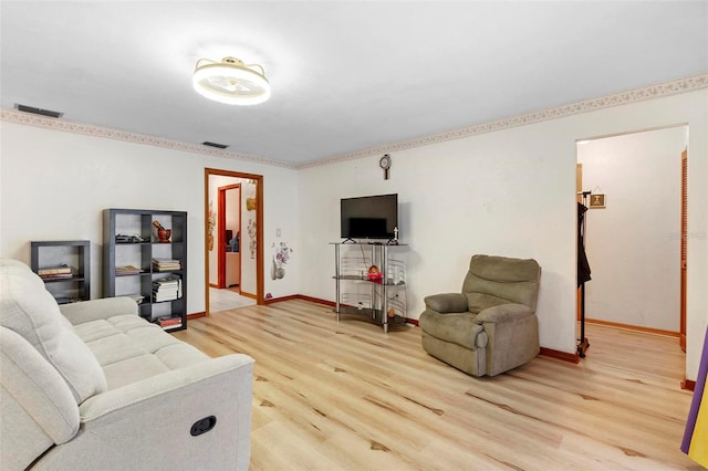 living area with light wood-style floors, baseboards, and visible vents