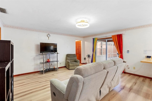 living area with light wood-type flooring, visible vents, and baseboards