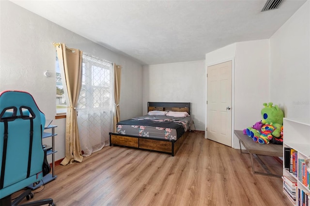 bedroom featuring light wood-style floors and visible vents