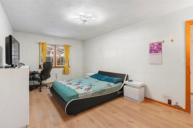 bedroom with wood finished floors and baseboards