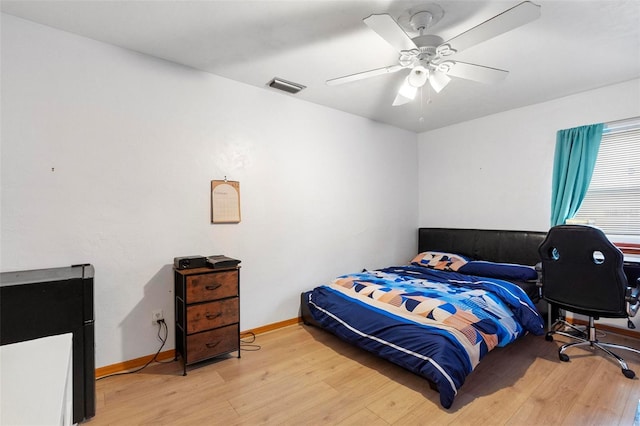 bedroom with light wood-type flooring, baseboards, visible vents, and ceiling fan