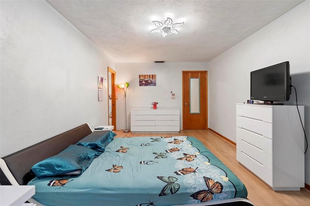 bedroom with light wood-style floors and baseboards