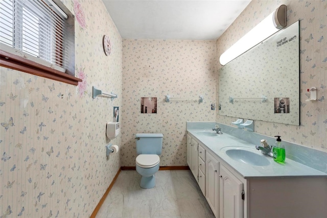 bathroom featuring double vanity, a sink, and wallpapered walls