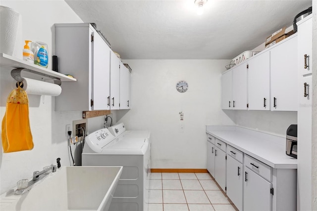 laundry room with cabinet space, baseboards, separate washer and dryer, a sink, and light tile patterned flooring