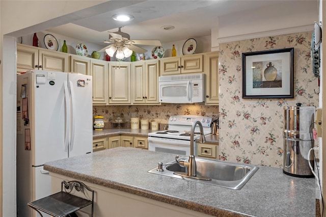 kitchen with cream cabinets, white appliances, a sink, a ceiling fan, and wallpapered walls