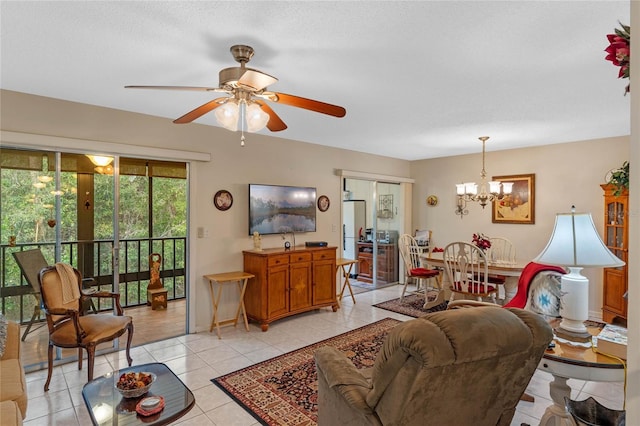 living area featuring ceiling fan with notable chandelier, a textured ceiling, baseboards, and light tile patterned floors