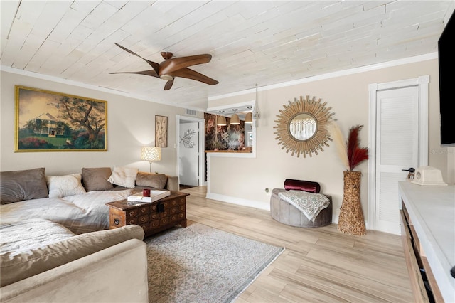 living area with crown molding, light wood finished floors, and ceiling fan