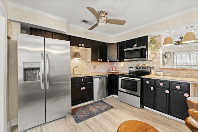 kitchen with stainless steel appliances, light countertops, visible vents, and decorative light fixtures