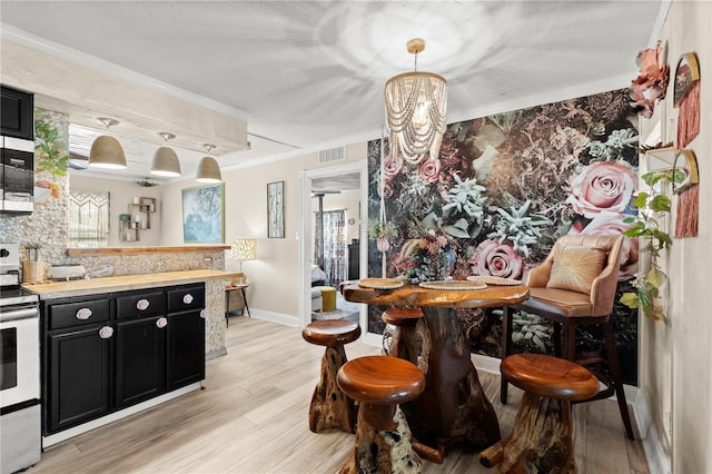 kitchen featuring visible vents, stainless steel electric range oven, light countertops, dark cabinetry, and pendant lighting