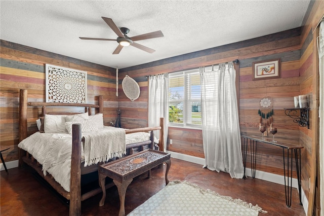 bedroom with baseboards, wooden walls, and a textured ceiling