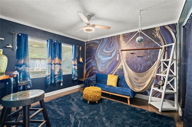 living area with a textured ceiling, a ceiling fan, and baseboards