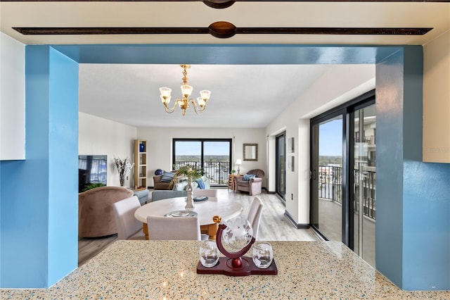 dining space featuring light wood-style flooring and a notable chandelier