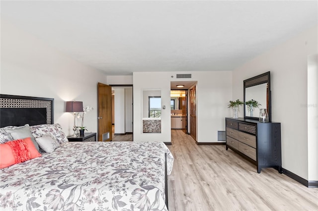 bedroom with light wood-type flooring, visible vents, and baseboards