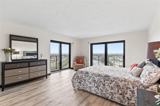 bedroom featuring a textured ceiling, access to outside, and light wood-style flooring