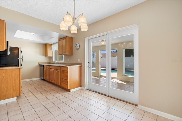 kitchen with light countertops, a chandelier, appliances with stainless steel finishes, and a sink