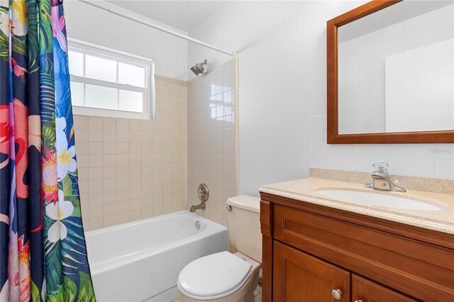 full bathroom featuring shower / tub combo, vanity, tasteful backsplash, and toilet